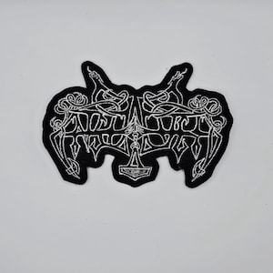May include: Black embroidered patch with white text and intricate designs. The patch features a stylized emblem with a hammer symbol and the word "NORSE" in a gothic font. The patch is likely for clothing or accessories.