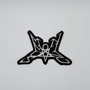 以下が含まれることがあります： 黒と白の刺繍パッチ。中央の円と逆矢印が付いた様式化された五芒星が特徴です。パッチは白いステッチの黒い背景で、大胆なコントラストを生み出しています。パッチはおそらく衣類やアクセサリー用です。