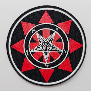 May include: A black and red embroidered patch with a pentagram and a goat's head in the center. The pentagram is surrounded by a circle with Hebrew characters.