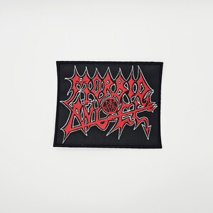May include: Black rectangular patch featuring the red text "MORBID ANGEL" in a jagged, stylized font. The patch has a white outline and a red pentagram in the center. Suitable for application on clothing or bags.