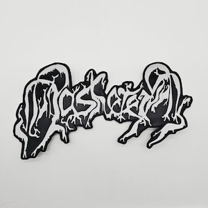 Könnte beinhalten: Schwarz-weißer gestickter Aufnäher mit dem Wort "LOST" in einer stilisierten, tropfenden Schriftart. Der Aufnäher hat einen schwarzen Hintergrund mit weißen Nähten und einen weißen Rand. Für Kleidung oder Accessoires.