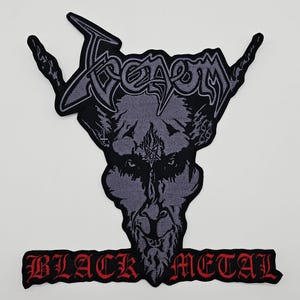May include: A black and gray patch featuring the word "Venom" above a demonic face with horns. The text "BLACK METAL" is displayed in red below the image. The patch is likely for a jacket or bag.