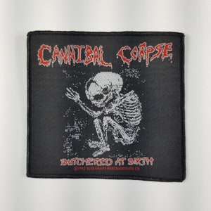 Puede incluir: Parche tejido negro con una imagen bordada en blanco y gris de un bebé esquelético con el texto "Cannibal Corpse Butchered At Birth" y el símbolo de copyright con "1992 Blue Grape Merchandising Co."