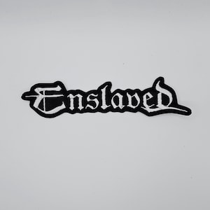 Puede incluir: Parche bordado en blanco y negro con la palabra "Enslaved" en fuente gótica. El parche tiene un borde negro y letras blancas, adecuado para chaquetas, bolsos u otros artículos de tela.