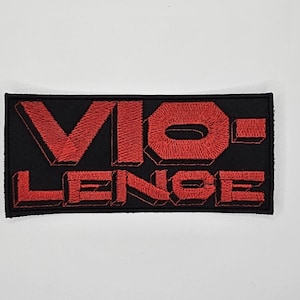 May include: Black rectangular patch with the word "VIOLENCE" embroidered in red, 3D-style lettering. The patch has a black border and is set against a white background.