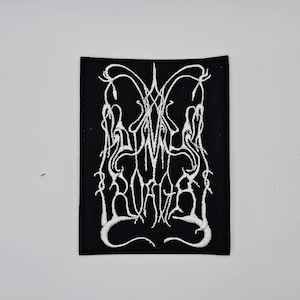 Peut inclure: Écusson rectangulaire noir avec texte brodé blanc et motif décoratif. Le texte semble être un nom de groupe ou un logo. L'écusson est destiné aux vêtements ou accessoires.