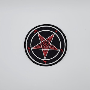 May include: Circular black patch featuring a red pentagram design with a demonic face at its centre. The patch is encircled by a white border and white symbols. Suitable for application on clothing or accessories.
