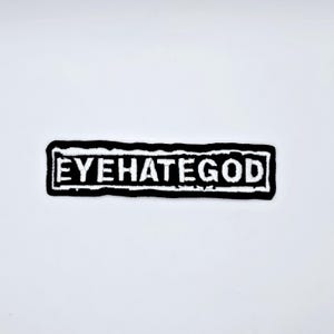 May include: Black and white embroidered patch with the text "EYEHATEGOD" in a rectangular shape. The text is in white, and the border and background are black. The patch is on a white background.