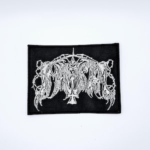 Könnte beinhalten: Schwarzer rechteckiger Aufnäher mit weiß gesticktem gotischem Schriftzug und Zierdesign. Der Aufnäher hat ein zentrales Kreuz und komplizierte, wirbelnde Muster, geeignet für Jacken, Taschen oder andere Stoffartikel.
