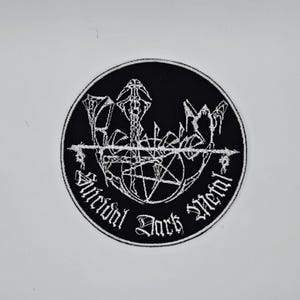 Può includere: Toppa ricamata in bianco e nero con le parole "Suicidal Dark Metal". La toppa presenta un disegno centrale con un pentagramma ed elementi gotici.