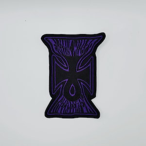 May include: Black patch with a purple iron cross design and the text "FRANKIE WANTS" and "FRANKIE WANTS" in a stylized font. The patch has a black border and is set against a white background.