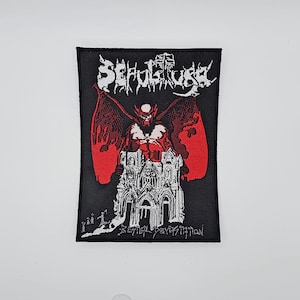 Puede incluir: Parche rectangular negro con la palabra "SEPULTURA" en blanco. Un gráfico rojo y negro representa un demonio alado sobre una catedral gótica. El texto "BESTIAL DEVASTATION" está debajo.