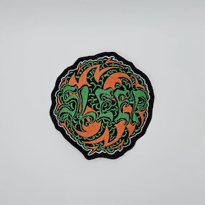 May include: Circular embroidered patch featuring the word "SLEEP" in green, stylized lettering. The patch has an orange and black design, with a black border. The patch is circular in shape.