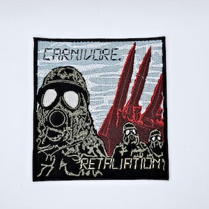 May include: Embroidered patch with a black border featuring the word "CARNIVORE" above a gas mask-wearing figure. Below, the word "RETALIATION" is displayed. Red, spiky shapes and two additional figures with gas masks are also visible.