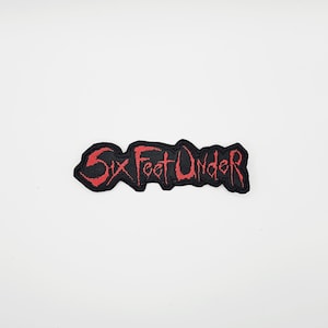 Può includere: Toppa ricamata nera con la scritta "Six Feet Under" in rosso, con lettering stilizzato. La toppa ha un bordo nero ed è progettata per essere cucita o stirata su tessuto. Il testo è audace e in stile gotico.