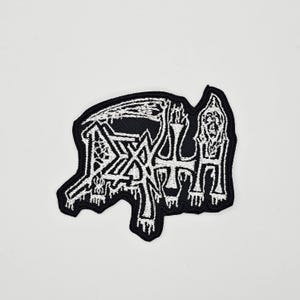 以下が含まれることがあります： ゴシック体の「DEATH」の文字が刺繍された白黒のパッチ。パッチは、頭蓋骨と交差した骨のデザインで、ユニークな形をしています。ジャケットやバッグ用である可能性が高いです。