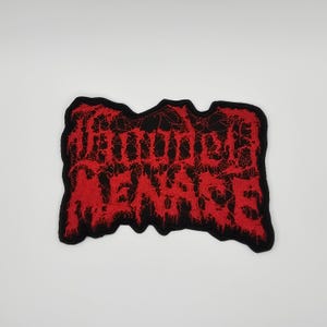 Può includere: Toppa ricamata con la scritta "WOUNDED VENGEANCE" in rosso, con bordo nero. Il lettering è stilizzato e l'insieme ha un aspetto invecchiato. Per personalizzare abiti e accessori.