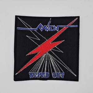 May include: Black square patch with the word "RAVEN" in blue, a red lightning bolt, and the words "WIPED OUT" in blue. White lines radiate from the lightning bolt.