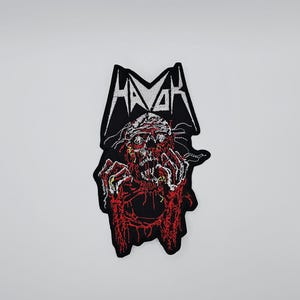 May include: Embroidered patch with a red and black zombie design and the word "HAVOK" in white, stylized text. The patch has a black border and is likely for clothing or accessories.
