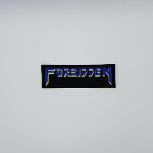 May include: A rectangular black patch with the word "FORBIDDEN" embroidered in blue and yellow thread. The text is stylized with a bold, slightly distressed font. The patch is likely for clothing or accessories.