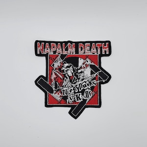 May include: Embroidered patch with the text "NAPALM DEATH" in red and white, above a graphic with the text "NAZIS DONT FUCK OFF". The patch has a black border and a red background.