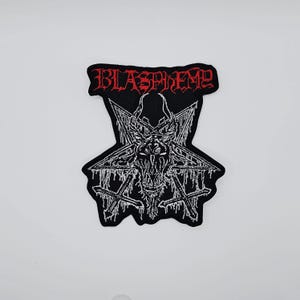 May include: Black patch with the word "BLASPHEME" in red, stylized lettering. The patch features a white, detailed illustration of a goat's head within a pentagram, with inverted crosses at the bottom. The design has a gothic, heavy metal aesthetic.