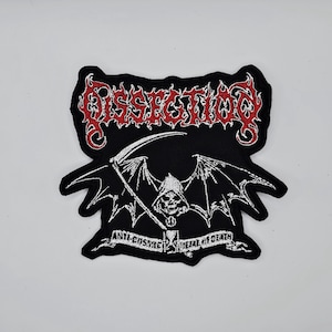 Può includere: Toppa nera con un disegno rosso e bianco. La parola "Dissection" è in alto. Sotto c'è una figura della morte con una falce e ali di pipistrello. Il testo "Anti-Cosmic Metal of Death" è in basso.