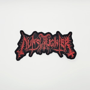Puede incluir: Parche bordado negro con la palabra "NUNSLAUGHTER" en rojo, con letras góticas estilizadas. El parche tiene una forma irregular y está diseñado para ropa o accesorios.