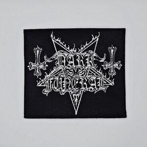 May include: A black square patch featuring the white text "DARK FUNERAL" in a gothic font, with a pentagram, crosses, and flame motifs. This patch is designed for application on clothing or accessories.
