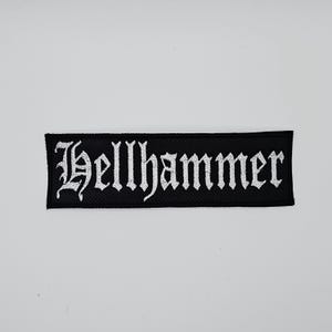 May include: A black, rectangular patch featuring the word "Hellhammer" in white, gothic-style lettering. This patch is designed for application on clothing or accessories.