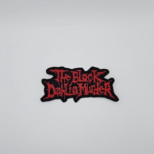 May include: A black embroidered patch featuring the text "The Black Dahlia Murder" in red, gothic-style lettering. The patch has an irregular outline and is designed to be sewn or ironed onto fabric items.