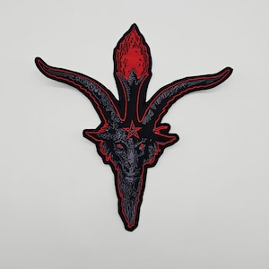 May include: A black and red embroidered patch featuring a stylized image of Baphomet. The patch has a black outline with red accents, including the eyes, flame, and star. The goat-like head is detailed with a pentagram.