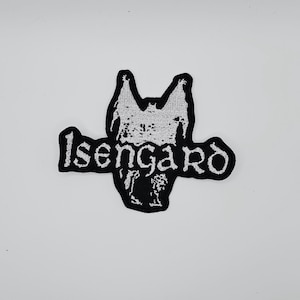 Puede incluir: Parche bordado en blanco y negro con la palabra "Isengard" y una criatura con forma de murciélago. El parche tiene un borde negro y es para ropa o accesorios.