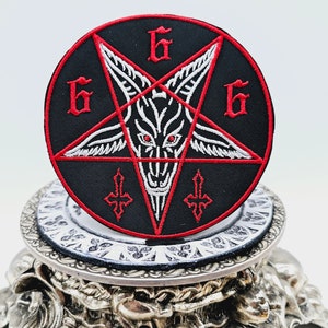 May include: A black and red embroidered patch with a pentagram, a goat's head, and the number 666.