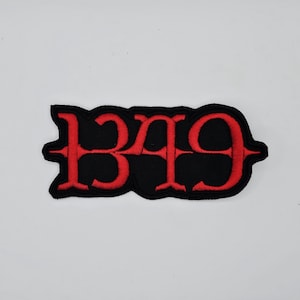 May include: Embroidered patch featuring the number "1349" in red thread on a black, irregular-shaped background. The numbers have a stylized, gothic font. The patch is likely designed for application on clothing or accessories.