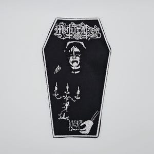 Può includere: Toppa nera a forma di bara con bordo bianco. La toppa presenta un'illustrazione bianca di una persona con il viso pallido, che tiene un candelabro. La parola "Mutilation" è nella parte superiore della toppa in lettere bianche stilizzate.