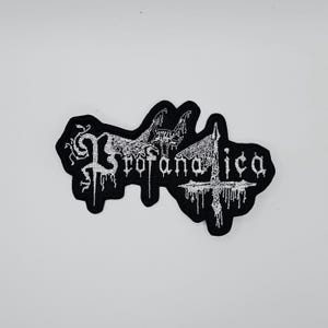 Puede incluir: Parche bordado negro con la palabra "Profanatica" en letras góticas blancas. El parche presenta un diseño estilizado con una criatura parecida a un murciélago y una cruz. El parche está sobre un fondo blanco.