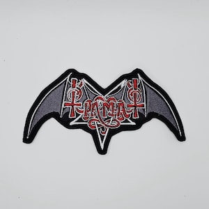 Op de afbeelding: Geborduurde patch in de vorm van een vleermuis met het woord "TIAMAT" in rood schrift. De vleermuisvleugels zijn grijs met een zwarte rand en de tekst is wit omlijnd. De patch heeft een zwarte rand.