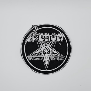 Op de afbeelding: Een ronde, zwarte patch met een witte rand. De patch toont het woord "Venom" in het wit, boven een witte pentagram met een geitenkop. De tekst "Welcome To Hell" staat eronder in het wit.