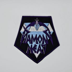 Könnte beinhalten: Schwarzer, fünfeckiger, gestickter Aufnäher mit den Worten "Diamond Head" in Lila, über einem hellblauen und weißen geometrischen Design. Der Aufnäher hat einen lila Rand und einen weißen Hintergrund.