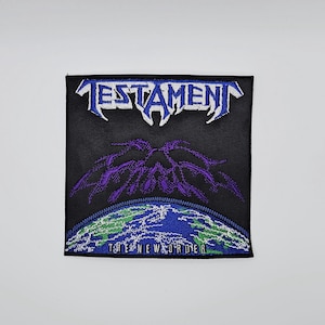 May include: Black square patch featuring the word "TESTAMENT" in blue and white. Below is a purple and black graphic over a blue and green earth, with the text "THE NEW ORDER" below.
