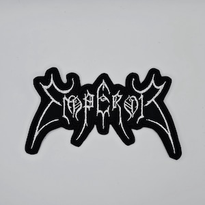 May include: Black and white embroidered patch featuring the word "EMPEROR" in a gothic font. The patch has a unique, stylized shape with pointed edges and a white border.