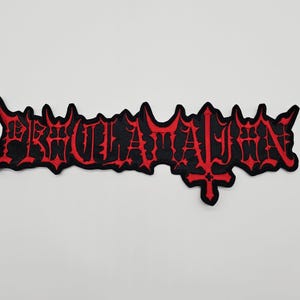 May include: Black and red embroidered patch with the word "PROCLAMATION" in a gothic font. The patch has a jagged edge and a cross symbol. The patch is likely for a jacket or bag.
