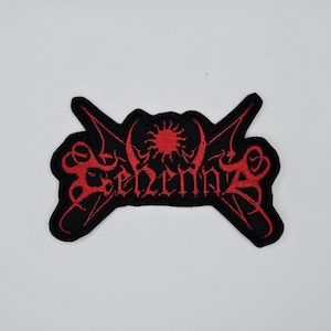 May include: A black patch with red embroidered text and a sun-like design. The word "Sehnsucht" is written in a gothic font. The patch has a unique shape with pointed edges, suitable for jackets or bags.