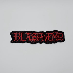 May include: Black embroidered patch with the word "BLASPHEME" in red, gothic-style lettering. The patch has a jagged, irregular border. The text is in a bold, stylized font, creating a striking visual effect.