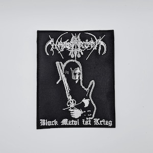 May include: Black embroidered patch with a white design. It features a figure holding a sword, and the text "Black Metal ist Krieg" in gothic lettering. The patch has a black background with white embroidery.