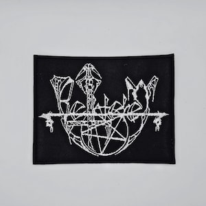 Può includere: Toppa rettangolare nera con scritta gotica bianca ricamata e un disegno a pentagramma. La toppa presenta la parola "Belphegor" in un carattere stilizzato, con elementi decorativi aggiuntivi.