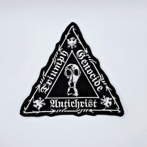 Puede incluir: Parche bordado en blanco y negro con forma triangular. El parche presenta las palabras "Triumph Genocide Antichrist" y un diseño de máscara de gas. El parche tiene un borde dentado.