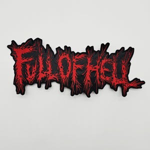 May include: A black embroidered patch featuring the text FULL OF HELL in a jagged, distressed red font. The lettering has a sharp, spiky aesthetic with irregular edges, and the entire design is cut to follow the contour of the text.