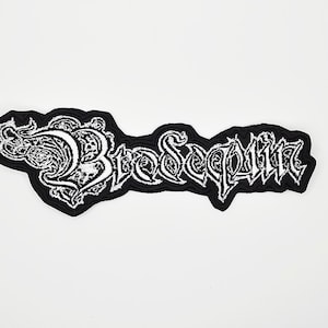 May include: Black and white embroidered patch with the word "Bloodsequin" in a gothic font. The patch has a black border and a white background for the text. The design includes decorative flourishes.